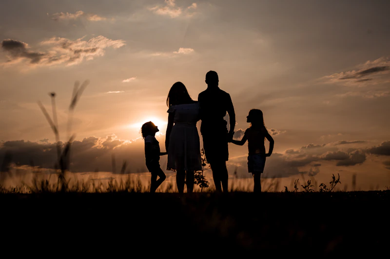 Familia caminando junta en un campo al atardecer